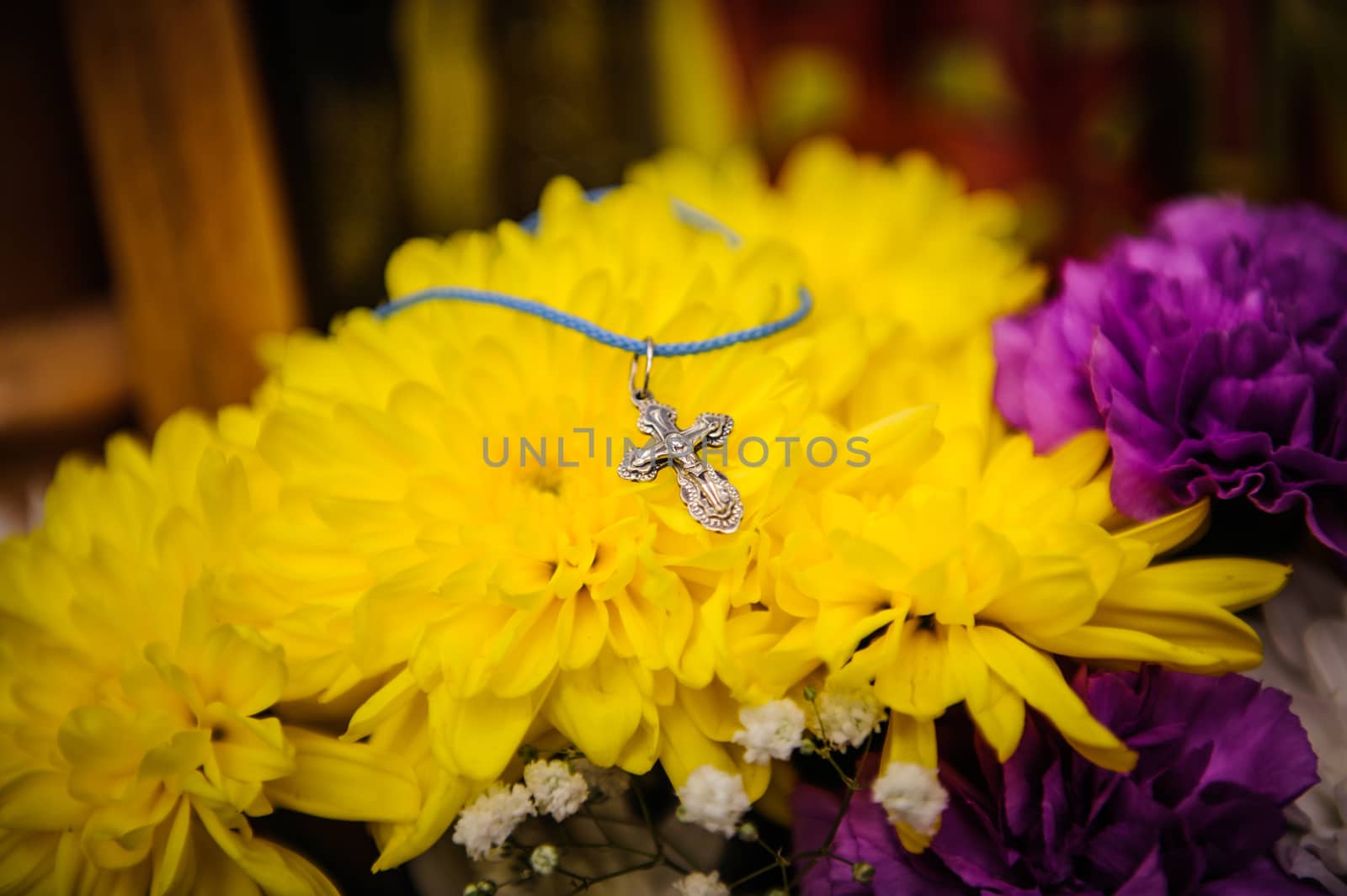 Orthodox cross lies on a background of yellow flowers