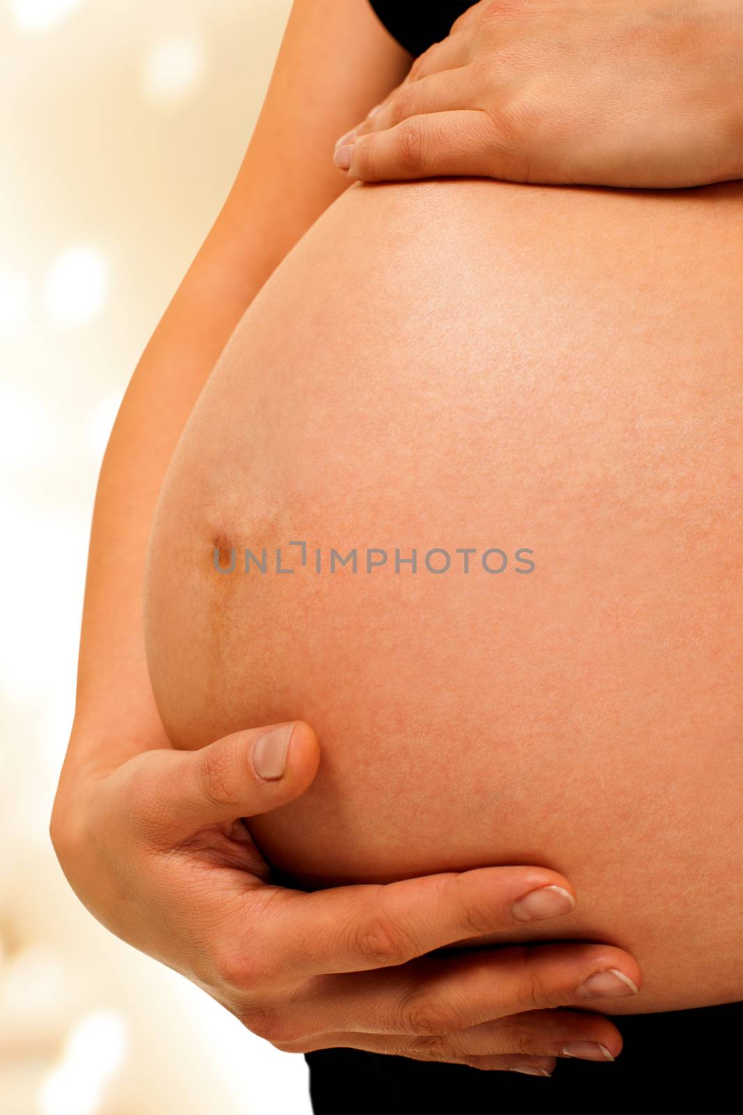 Pregnant woman is holding her abdomen on light background, isolated with work path.