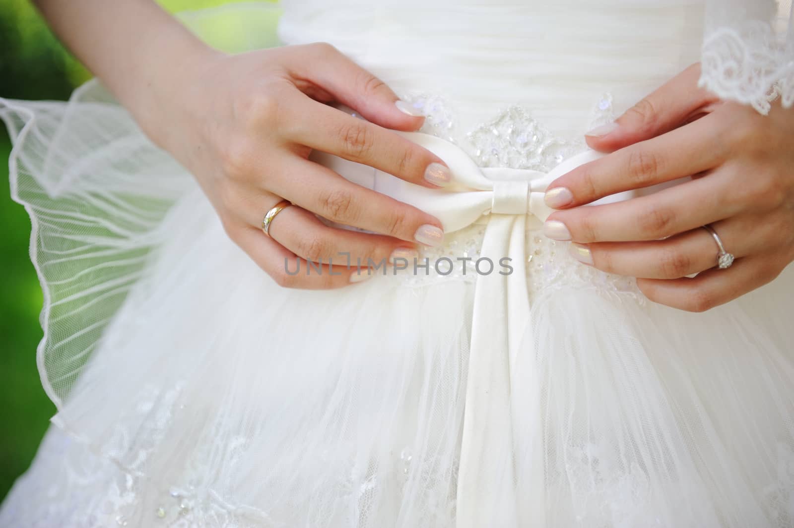 Bride holding a bow on a wedding dress
