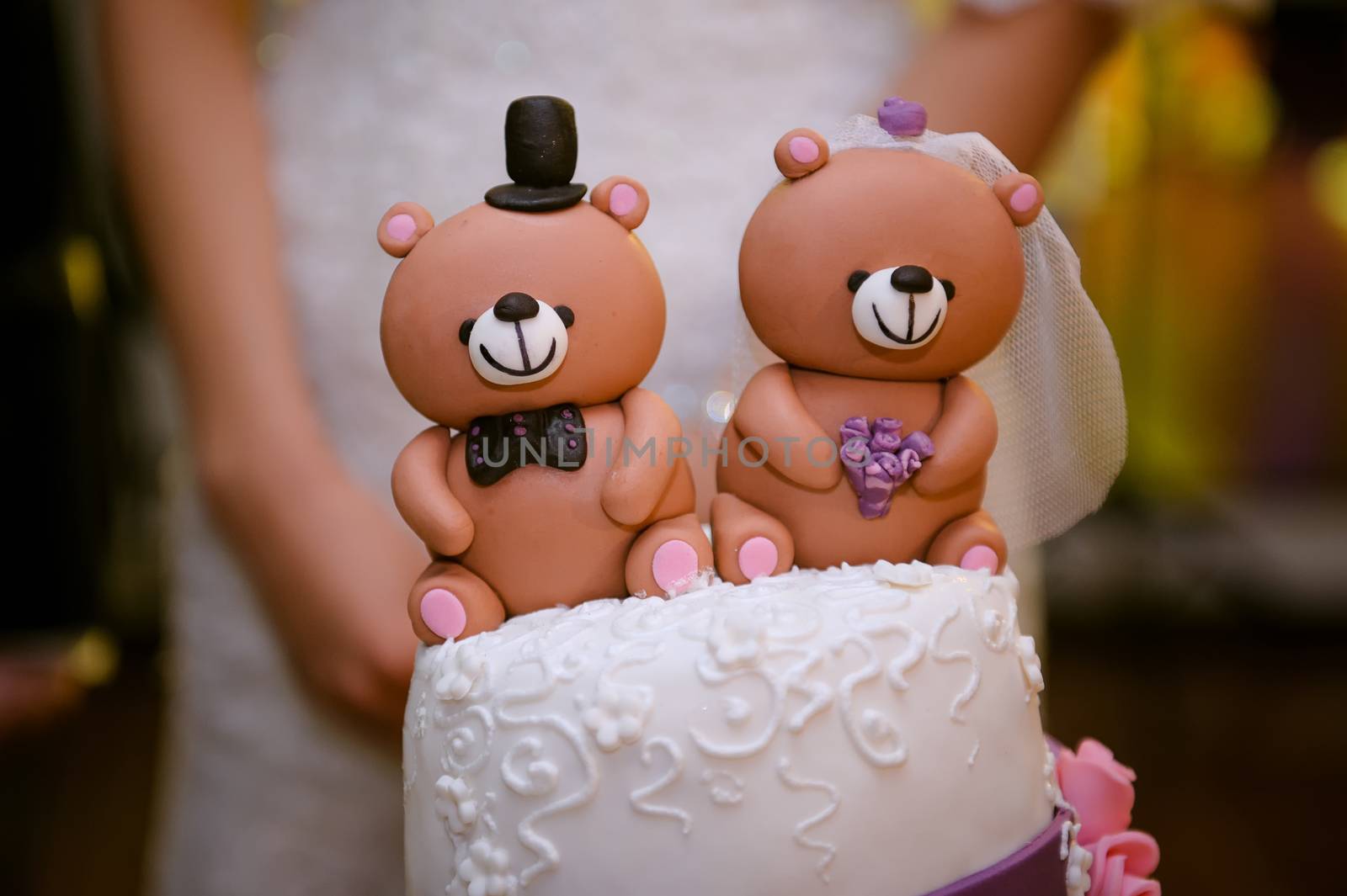 beautiful wedding cake with a teddy bear at the top