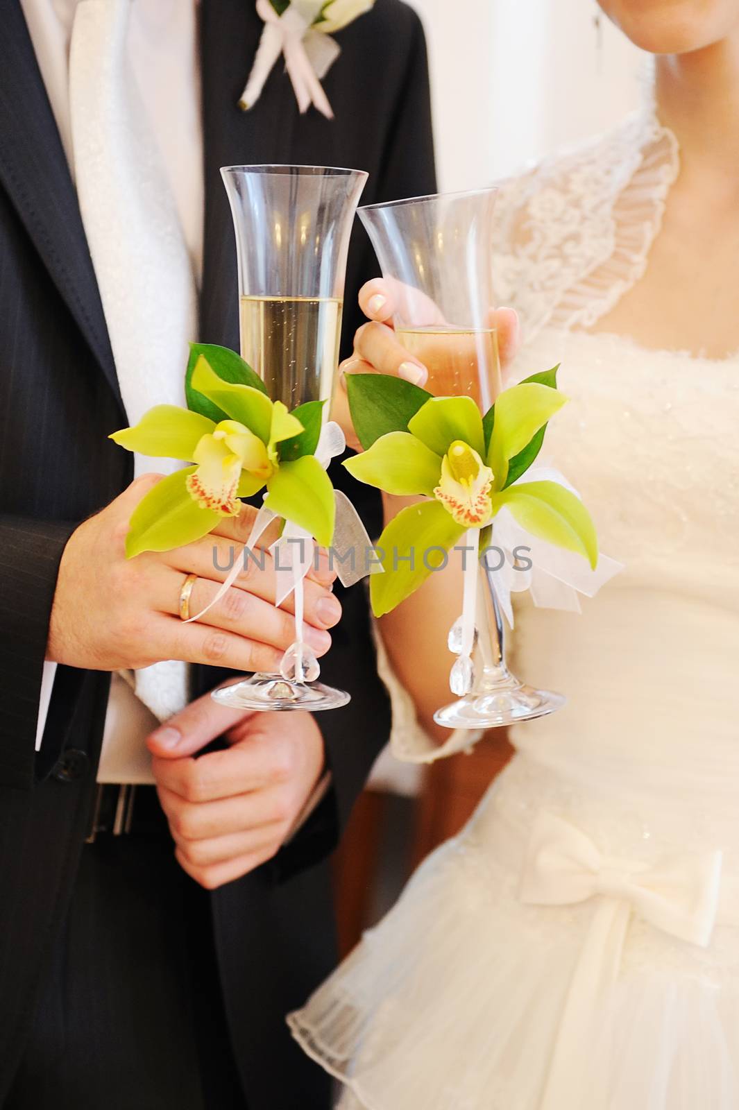 bride and groom holding champagne glasses by timonko