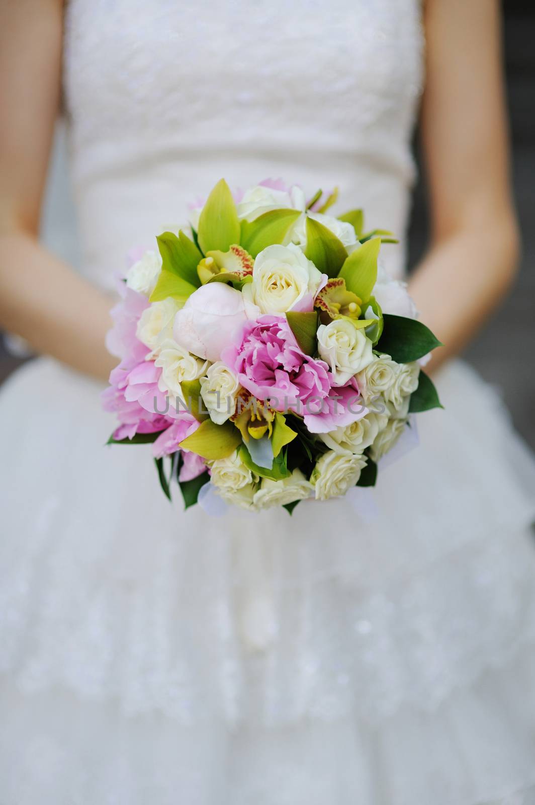 Bride holding white wedding bouquet of roses