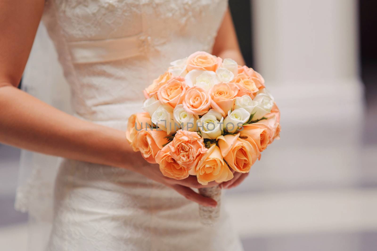 bride holding a wedding bouquet with white and pink roses