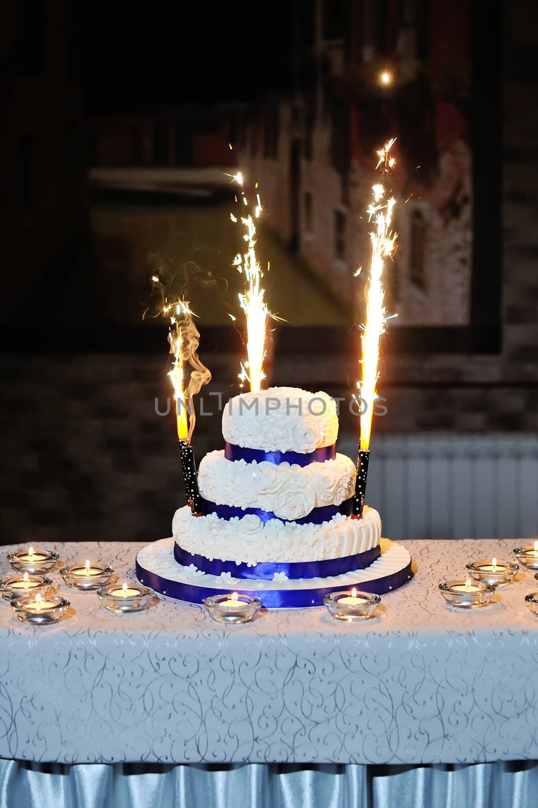 beautiful wedding cake on a table with candles