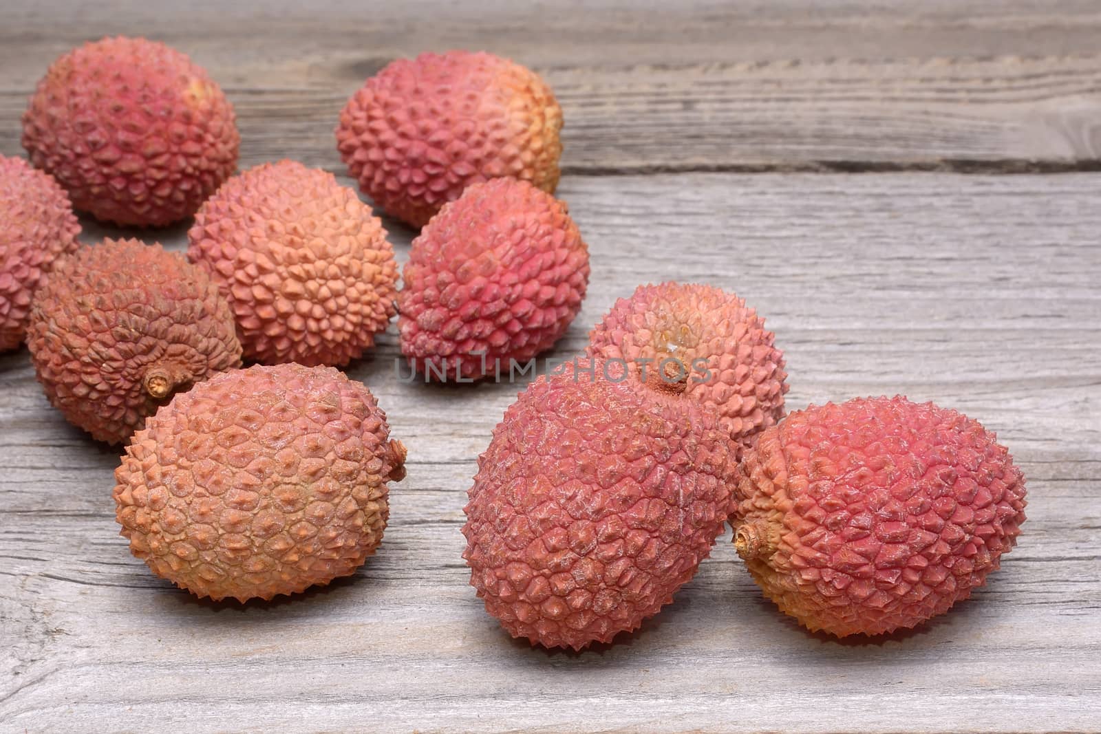 Lychee group arranged on a wooden table by comet