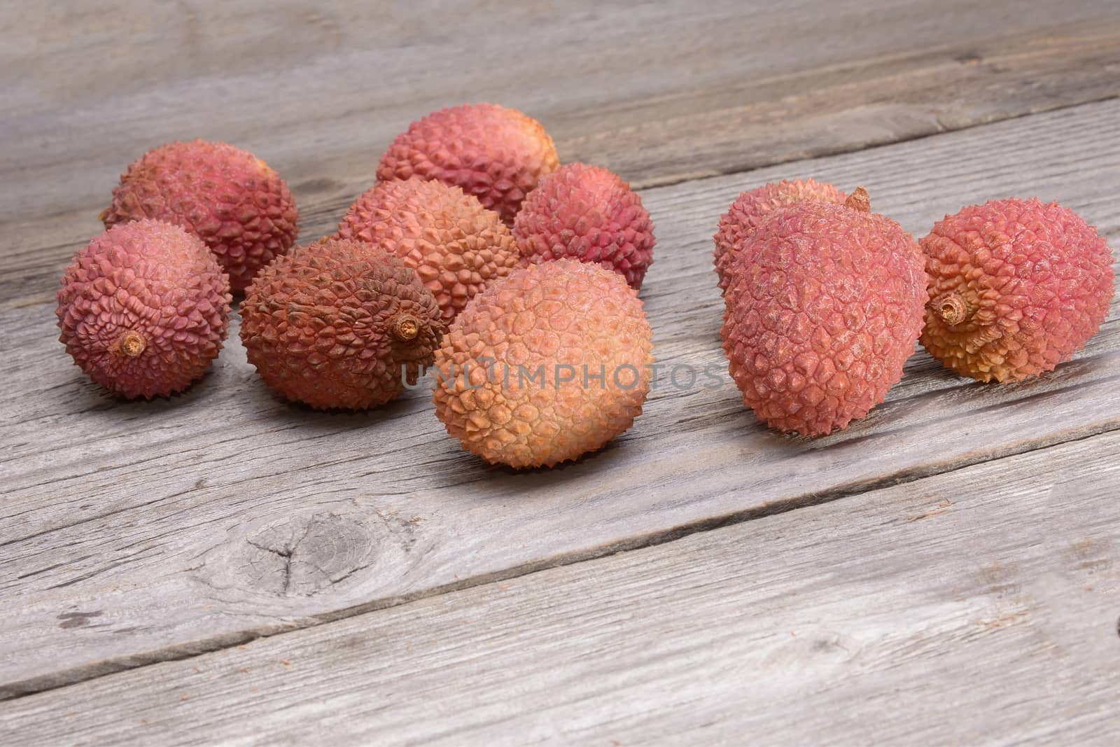 Lychee group arranged on a wooden table by comet