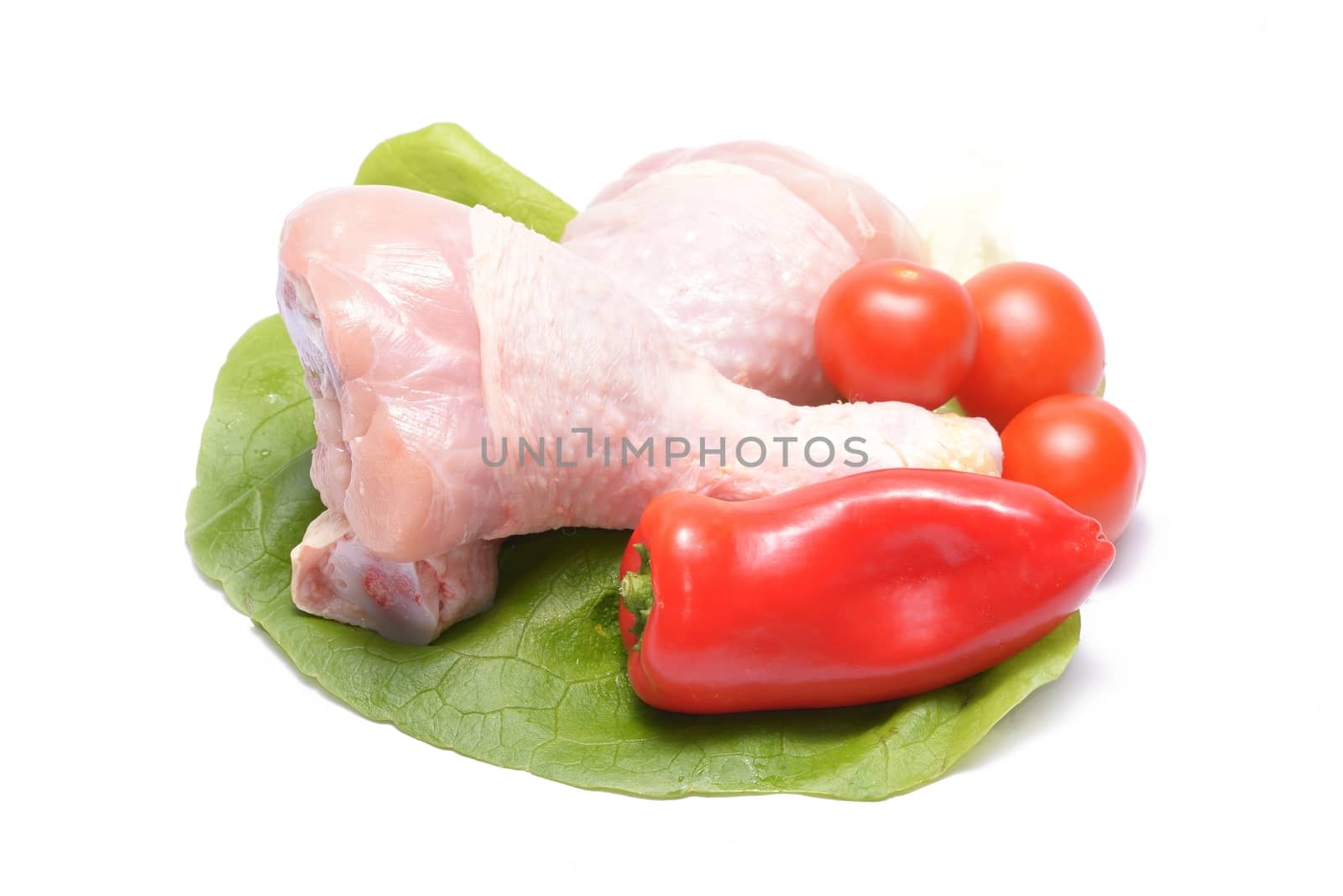 Fresh chicken drumsticks isolated on white background with vegetables by comet