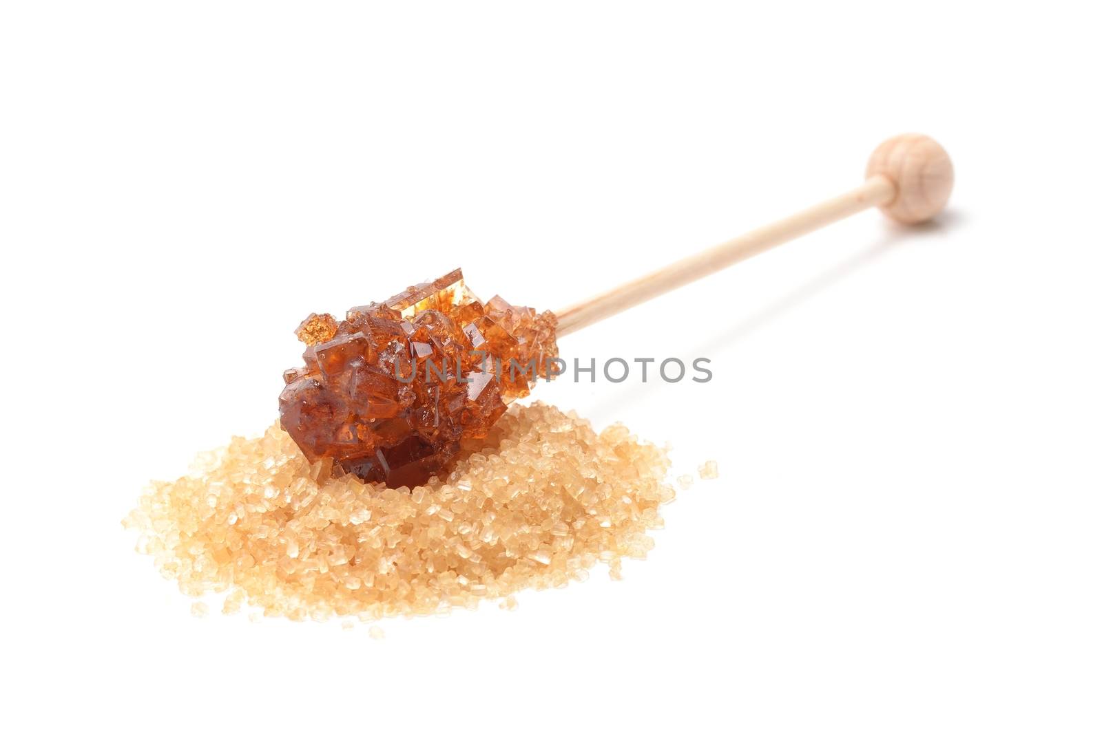 Brown sugar crystal on wooden stick isolated over white background