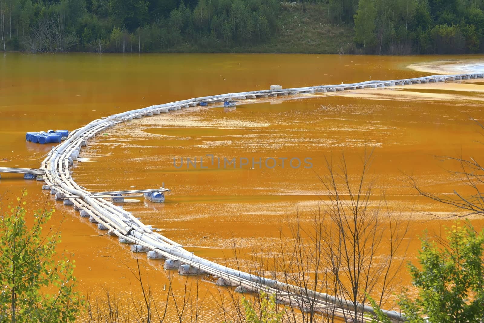 Red lake polluted with dead trees and a flooded church in Romania, Geamana by comet