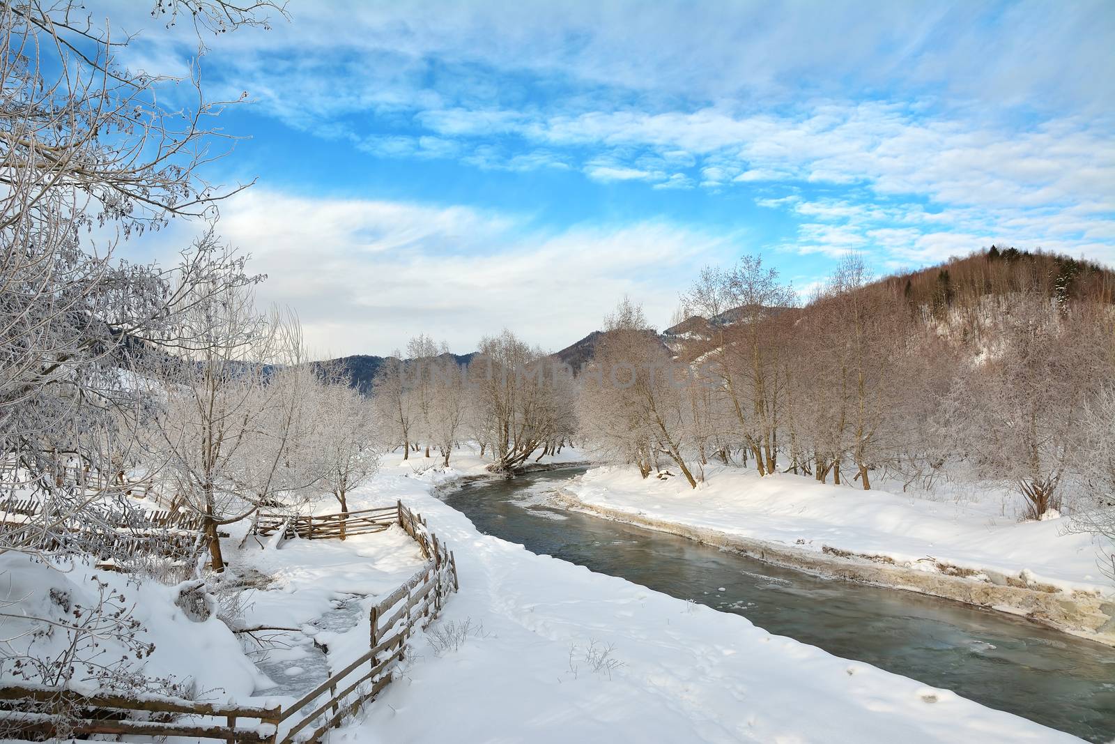 Frozen river and trees in winter season. by comet