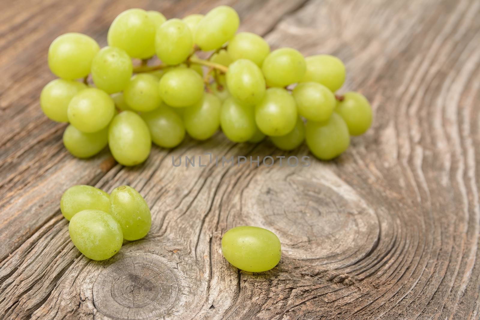 green grapes on wooden background by comet