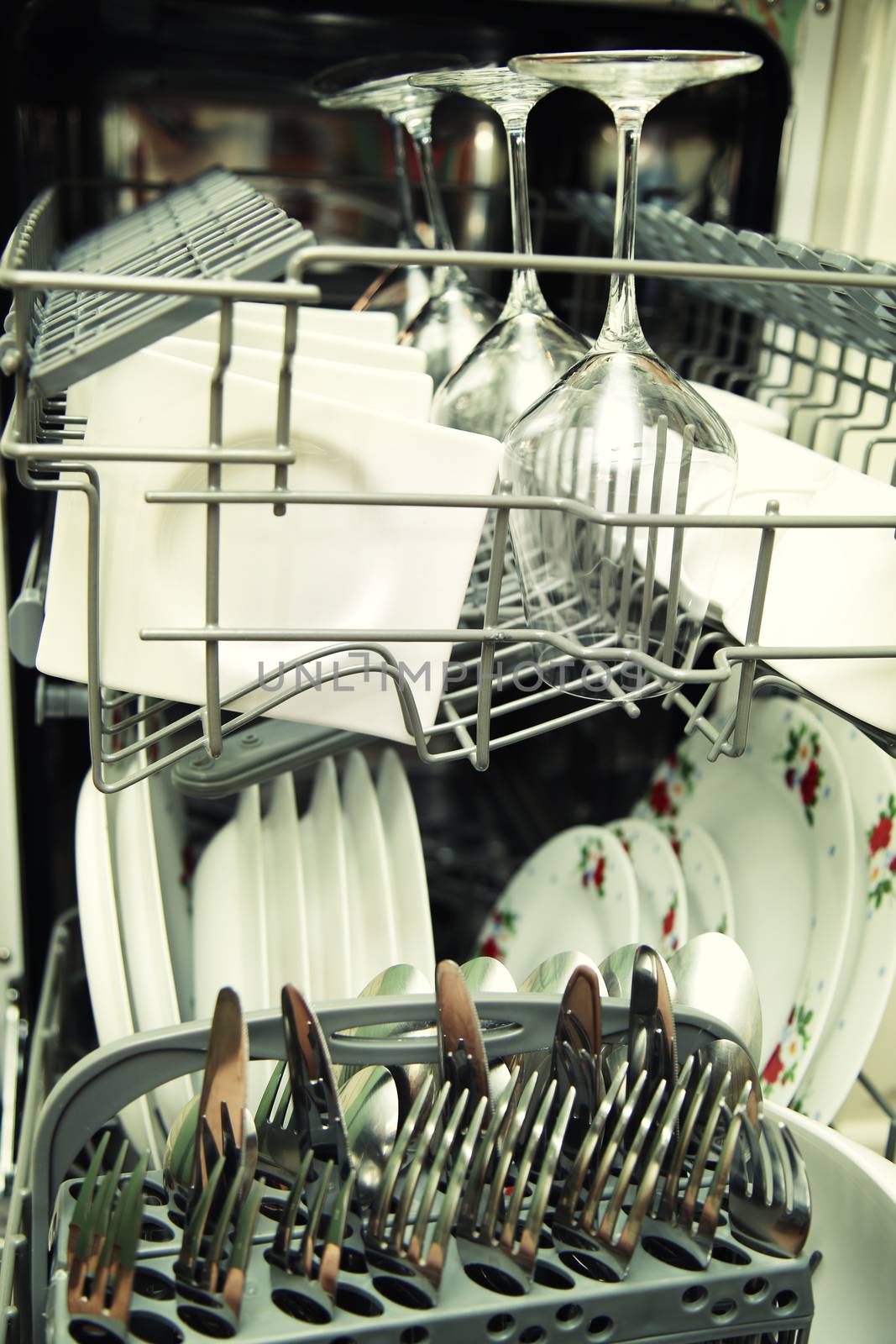 details of Open dishwasher with clean utensils