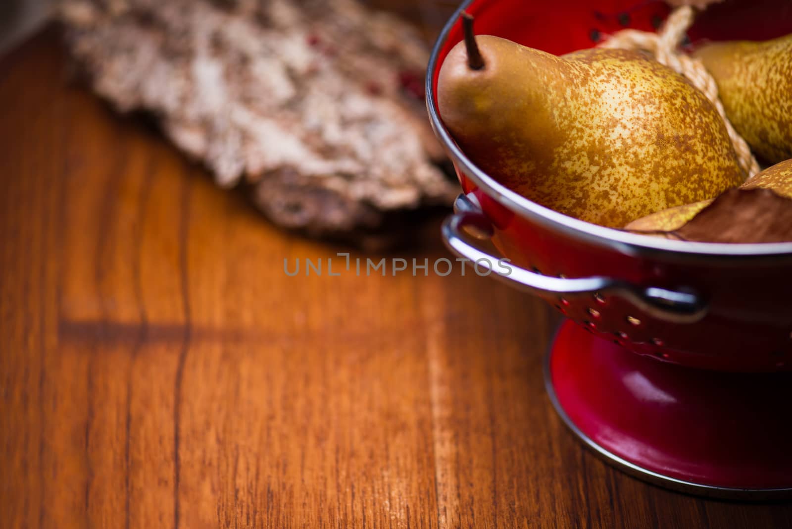Pears on red colander by cristinphotos