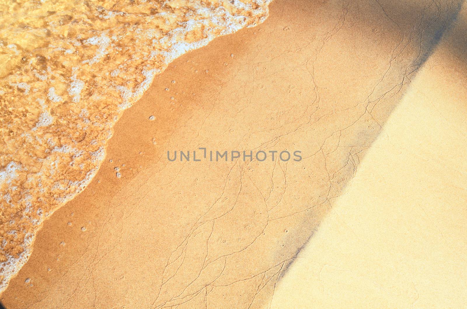 Transparent waves on the sandy beach