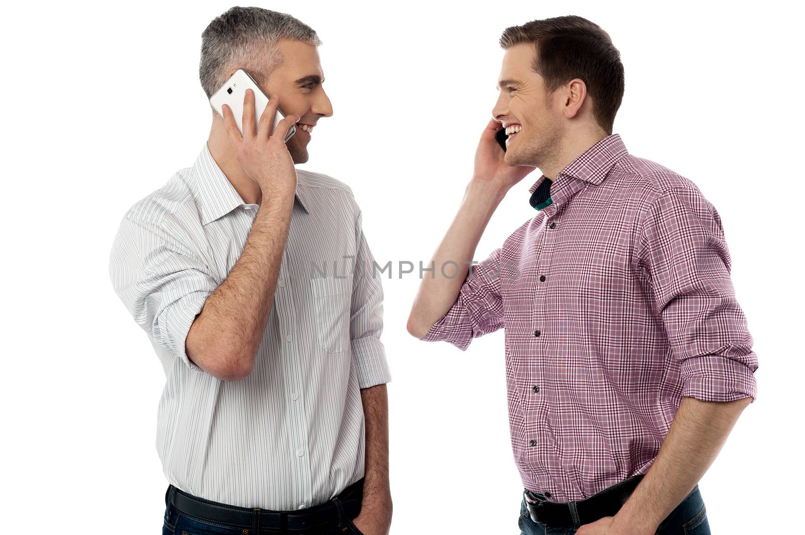 Two young friends happily talking on mobile phone