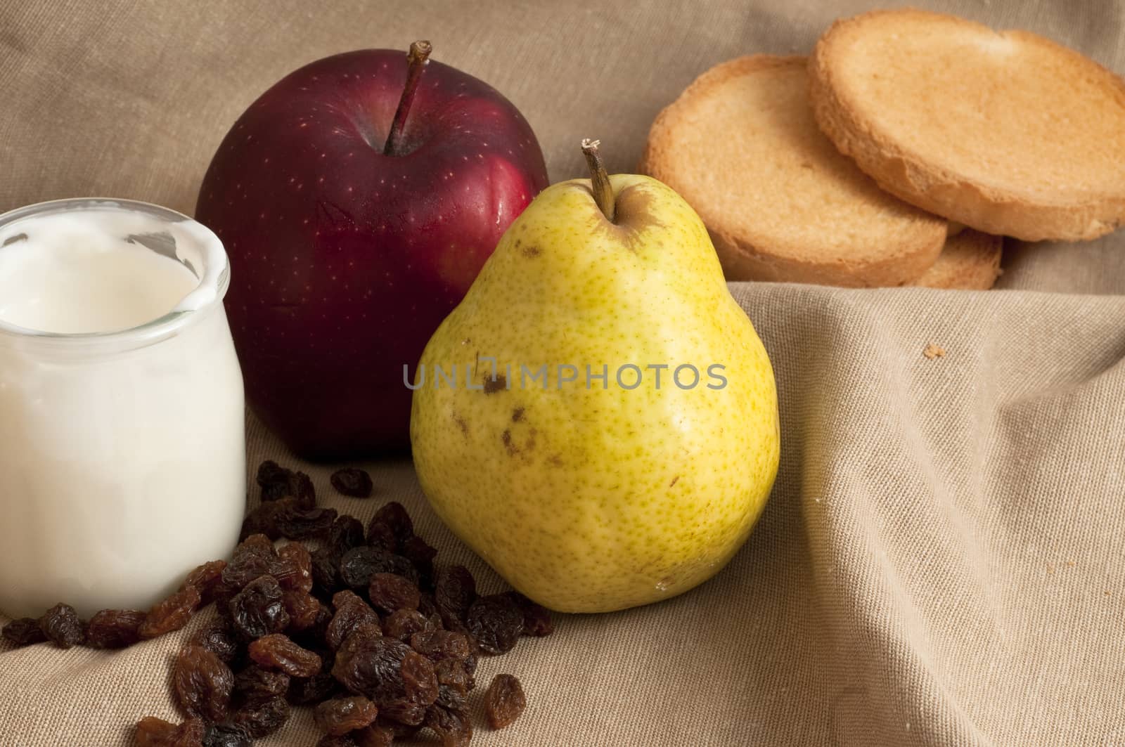 breakfast served with yogurt, apple and pear on a towel