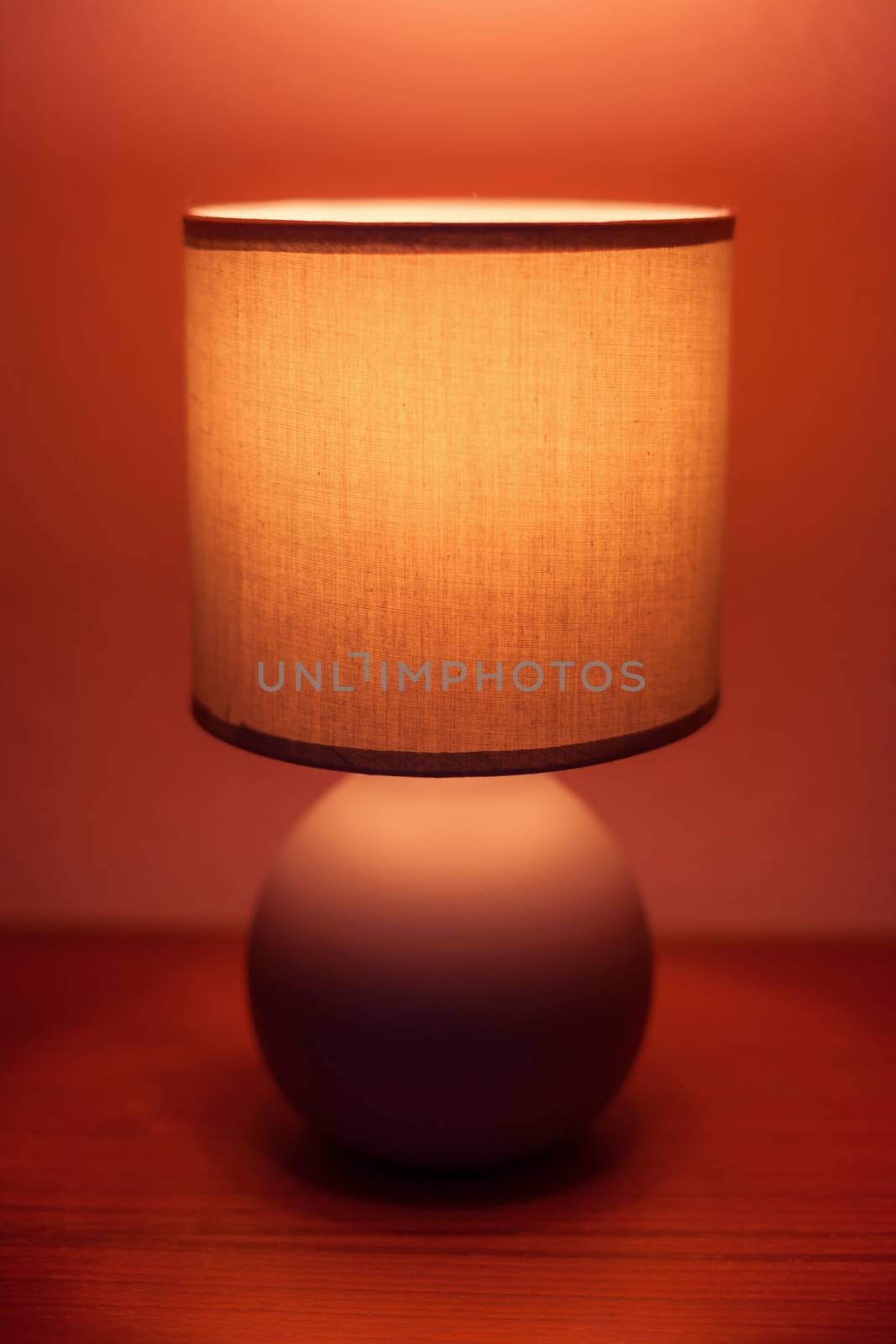 Lit lamp on a shelf in moody light