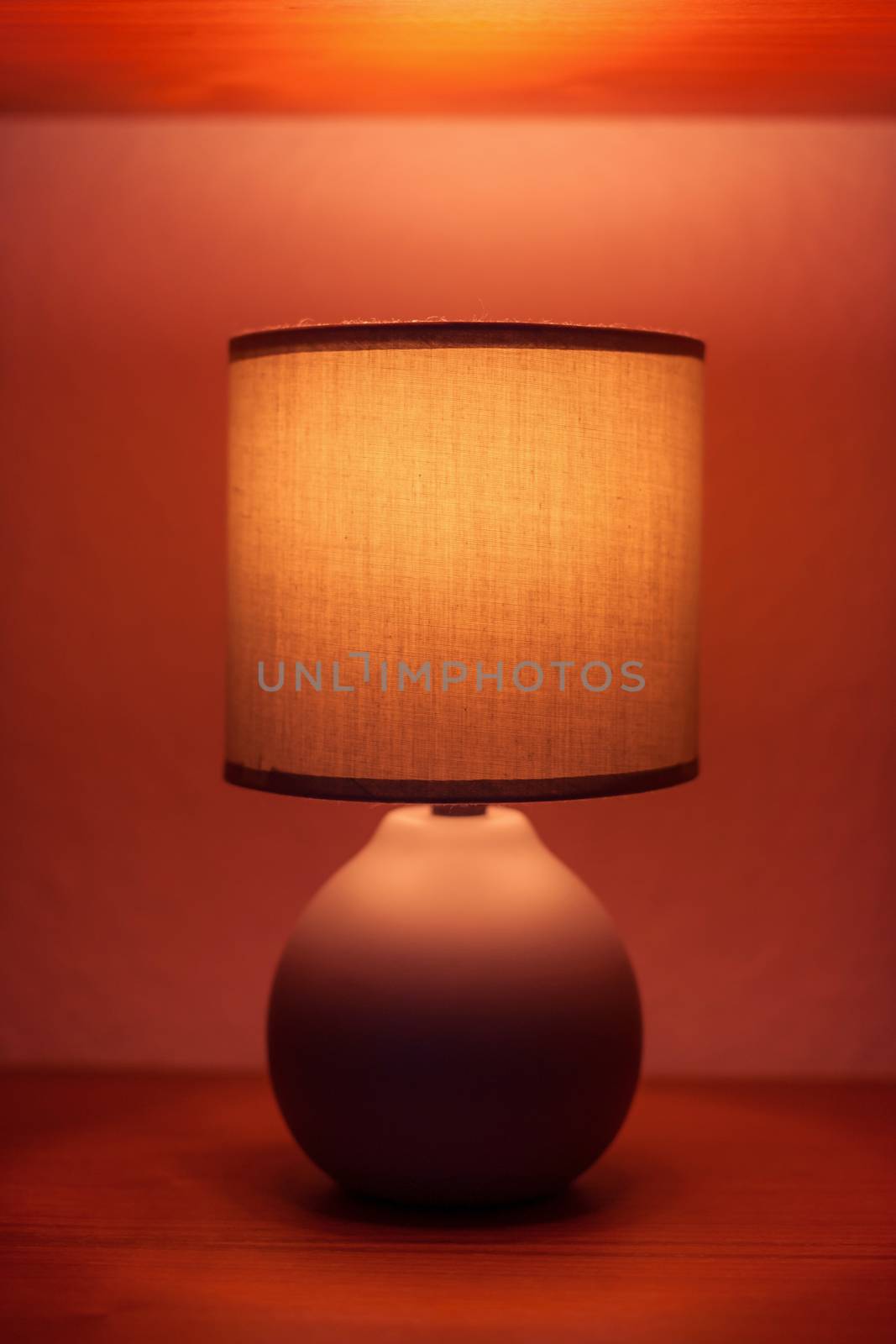 Lit lamp on a shelf in moody light