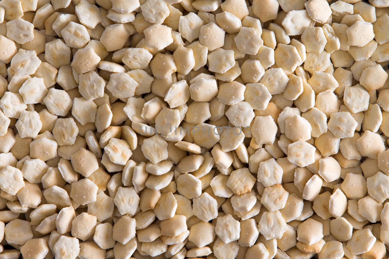 Background texture of small oven-baked oyster crackers usually served with soup in a full frame closeup view from above