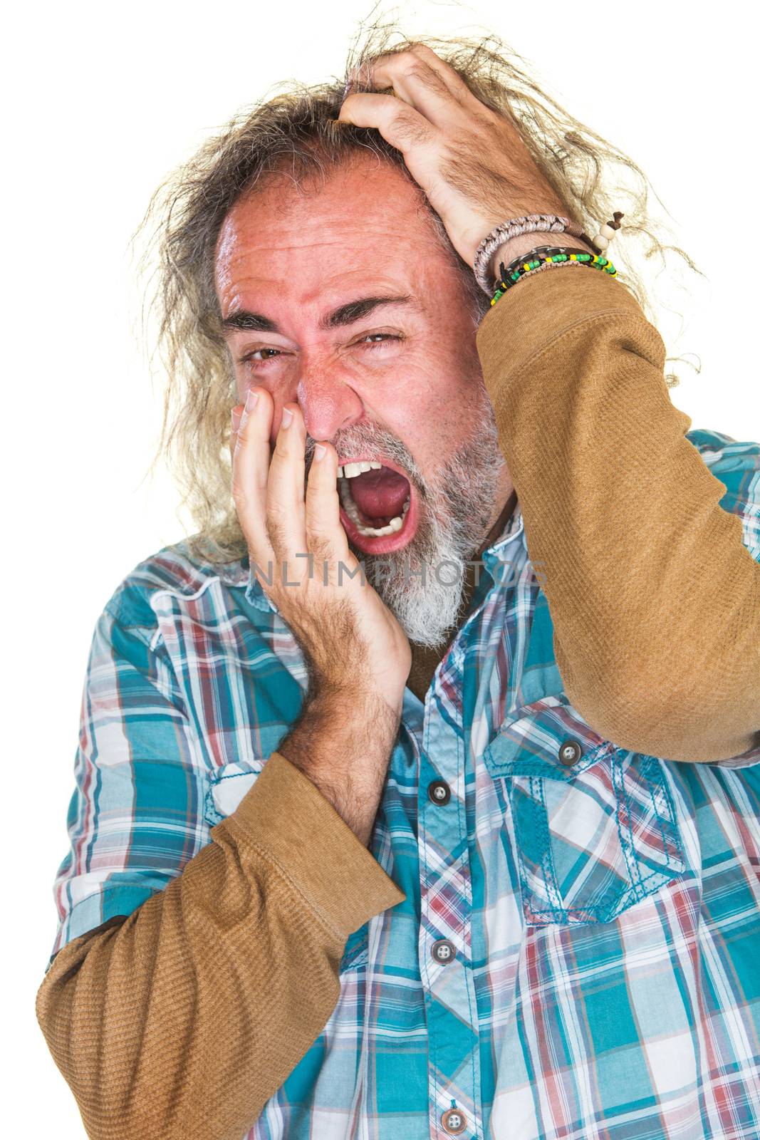 European man in beard yawning and scratching head