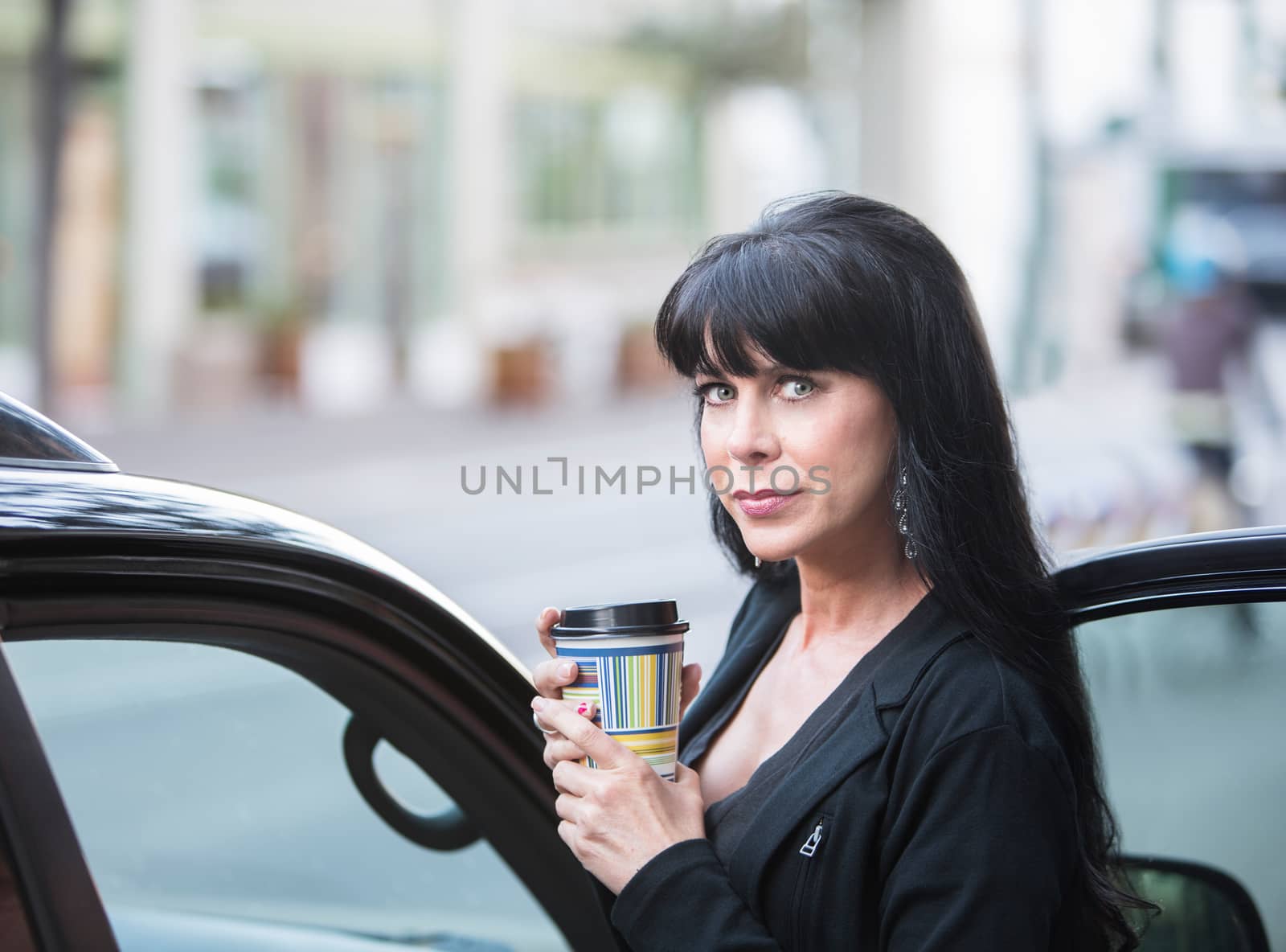 Attractive woman downtown in the morning with coffee cup