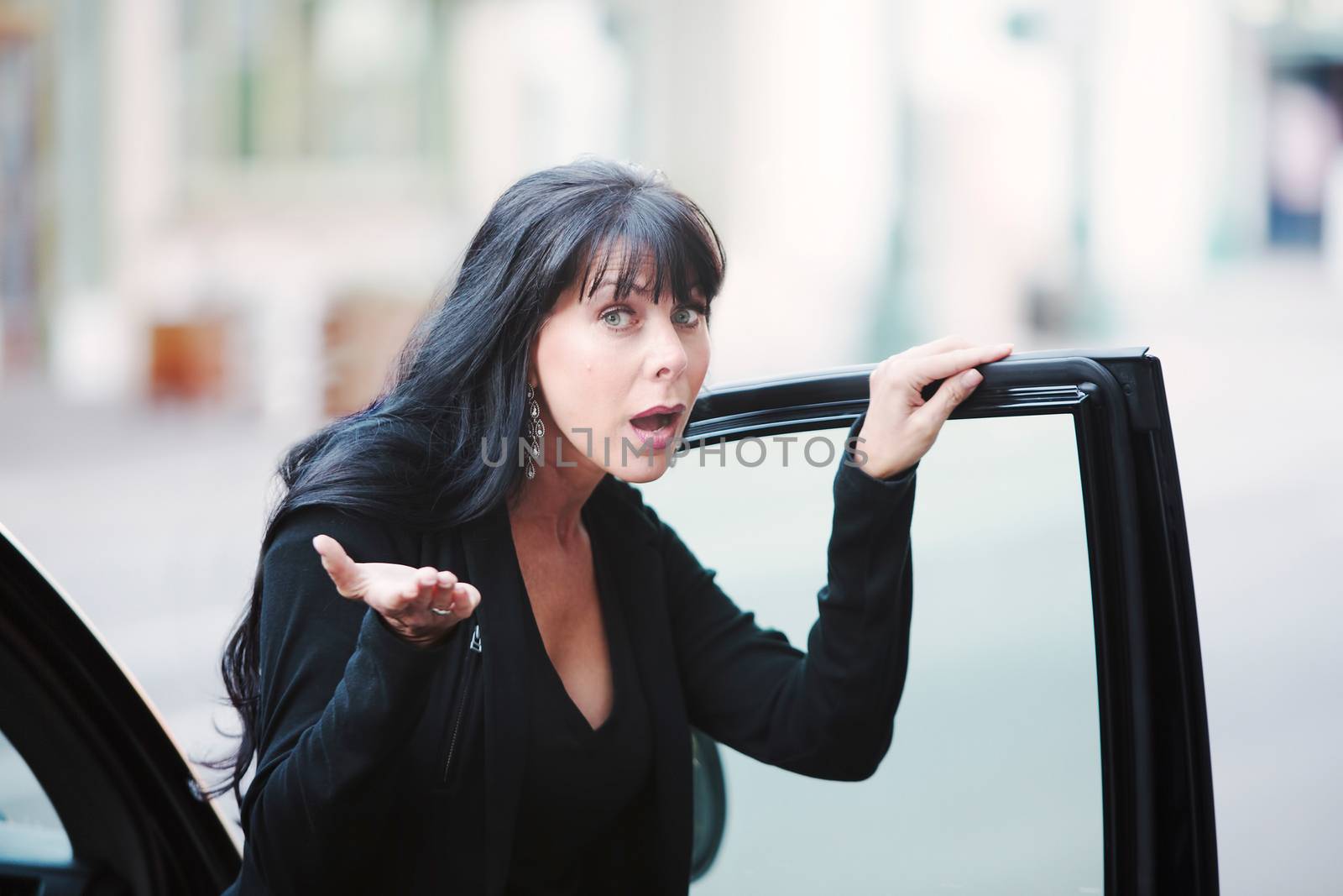 Skeptical mature woman near car in urban environment