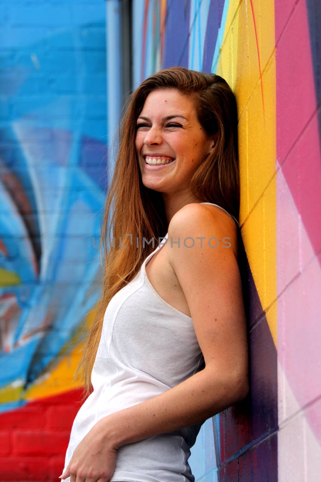 Young woman standing in front of a colorful background.