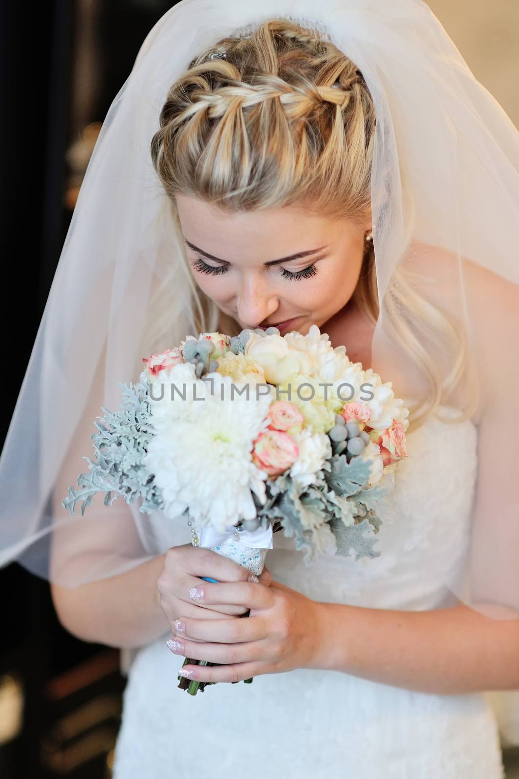 Happy bride smelling bridal bouquet