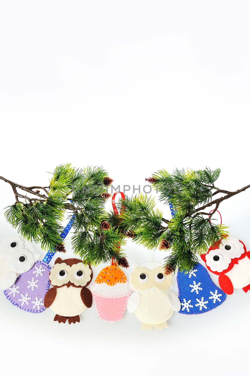 Handmade Christmas decorations made of felt hanging on a rope. Felt Santa boots, felt Christmas tree and felt mittens. owl, a bell and a Cake