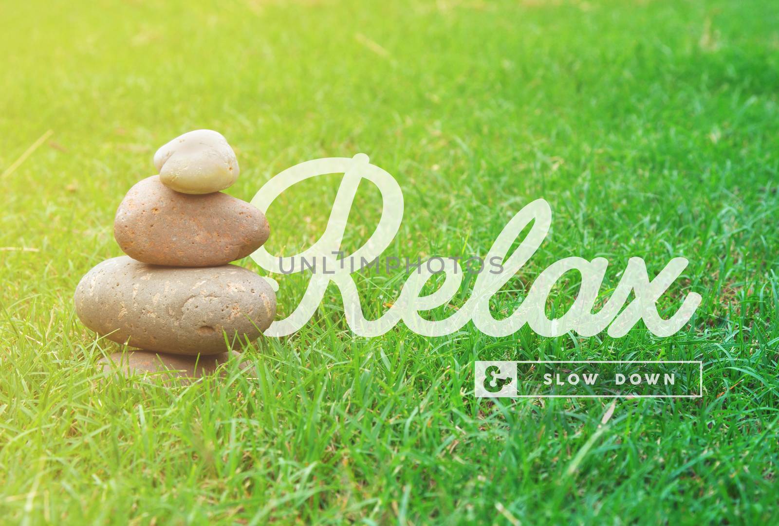 Relax and slow down motivational inspiring quote with balance zen stones and green grass background ideal for spa and wellness poster.