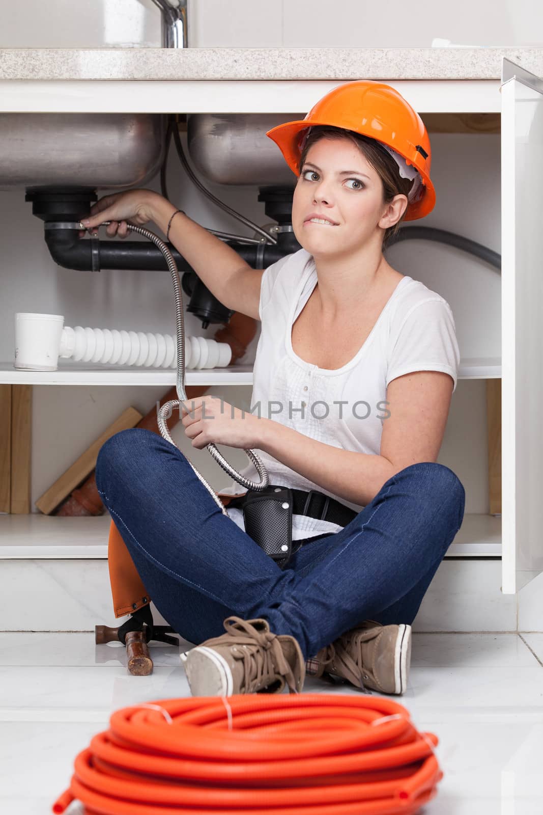 Fun woman sitting repairing the pipe