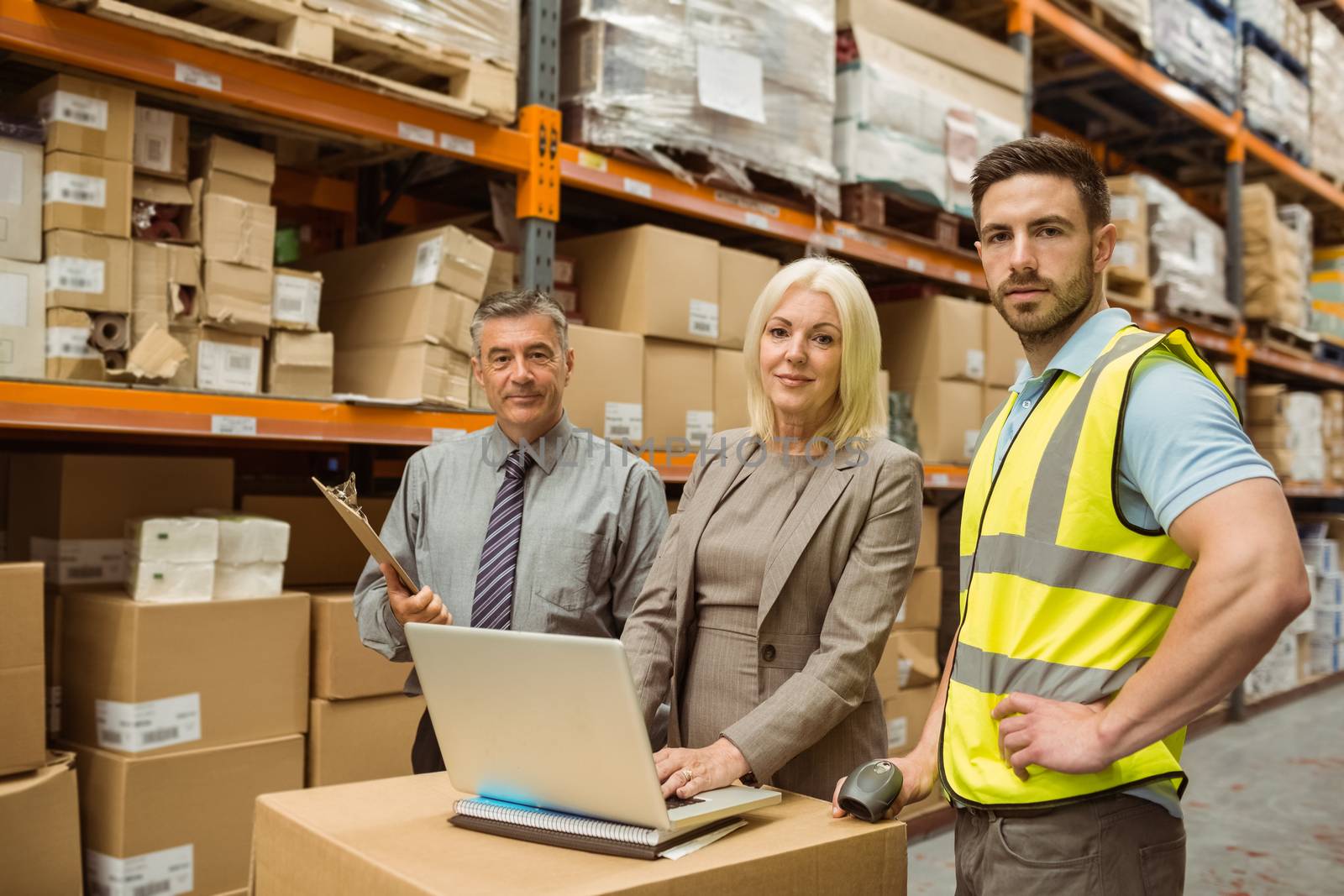 Smiling warehouse team working together on laptop by Wavebreakmedia