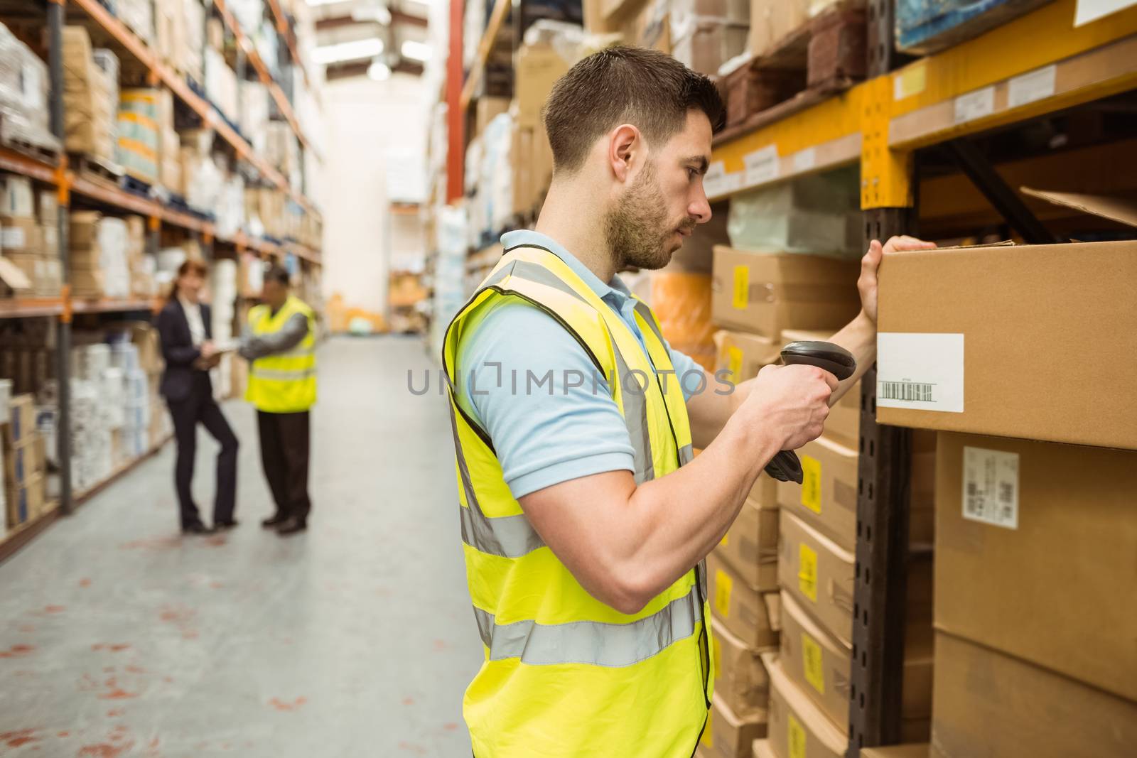 Warehouse worker scanning barcode on box by Wavebreakmedia