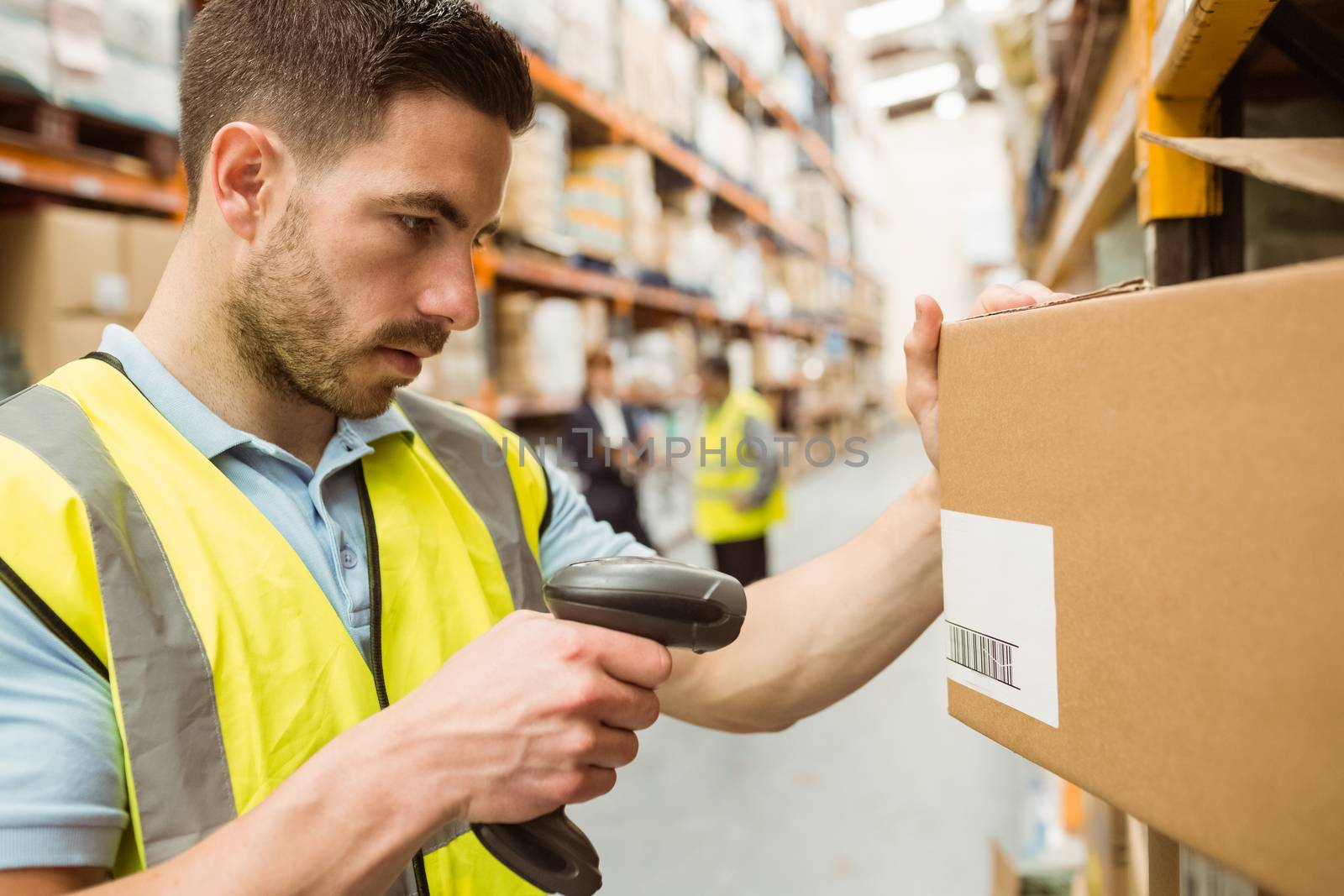 Warehouse worker scanning barcodes on boxes by Wavebreakmedia