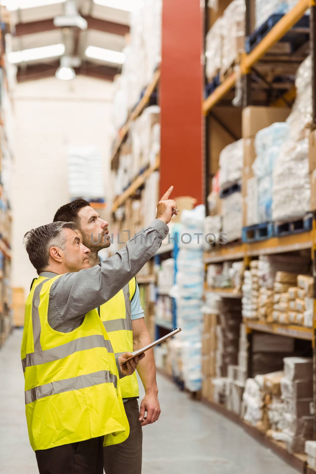 Warehouse manager talking with worker in a large warehouse