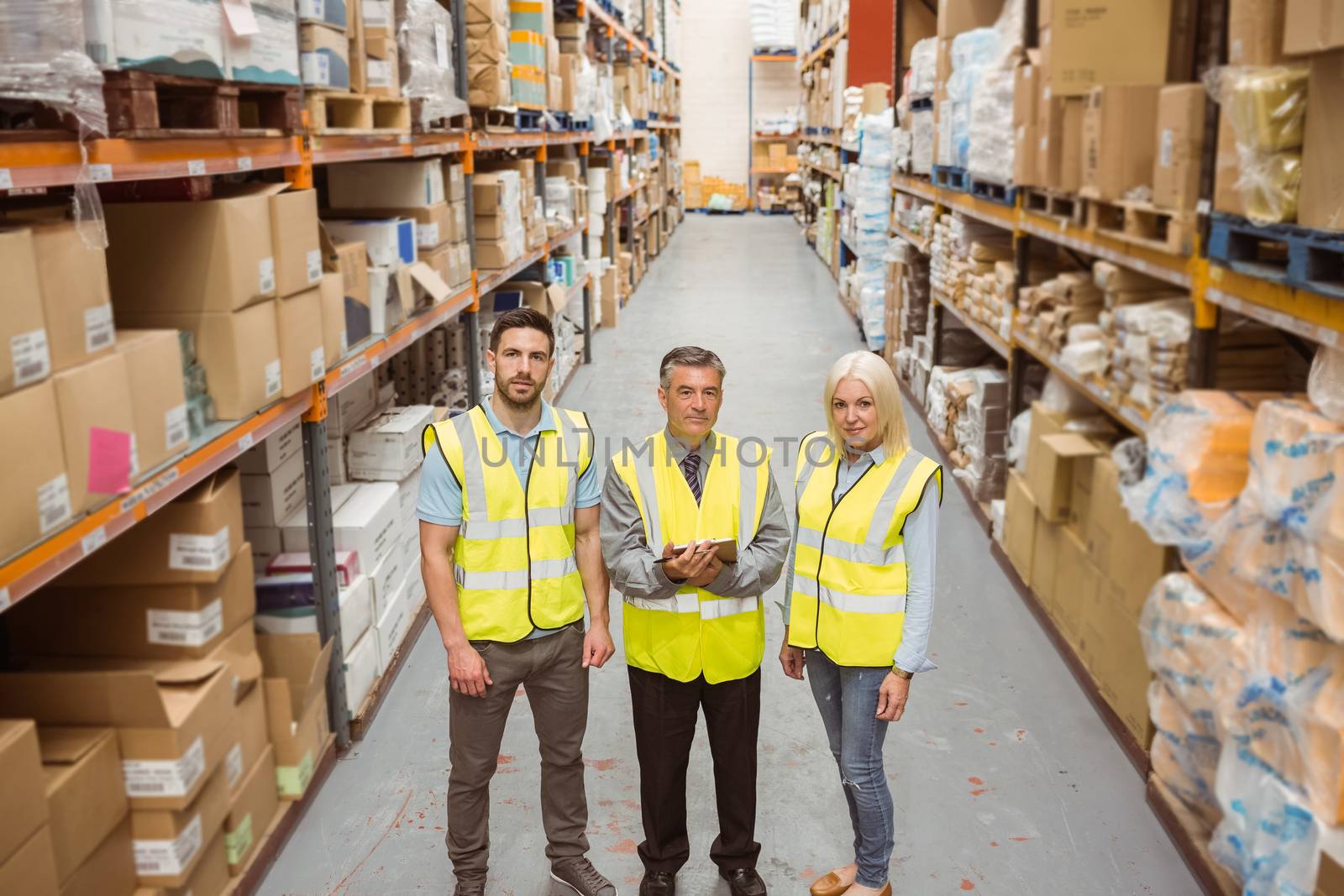 Warehouse team smiling at camera in a large warehouse