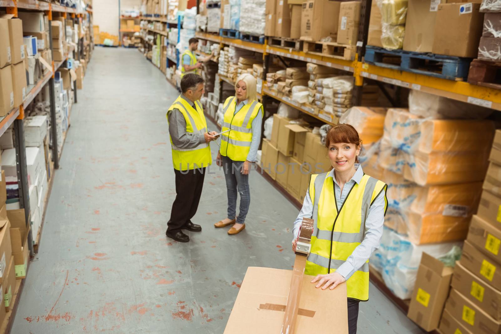 Warehouse worker sealing cardboard boxes for shipping by Wavebreakmedia