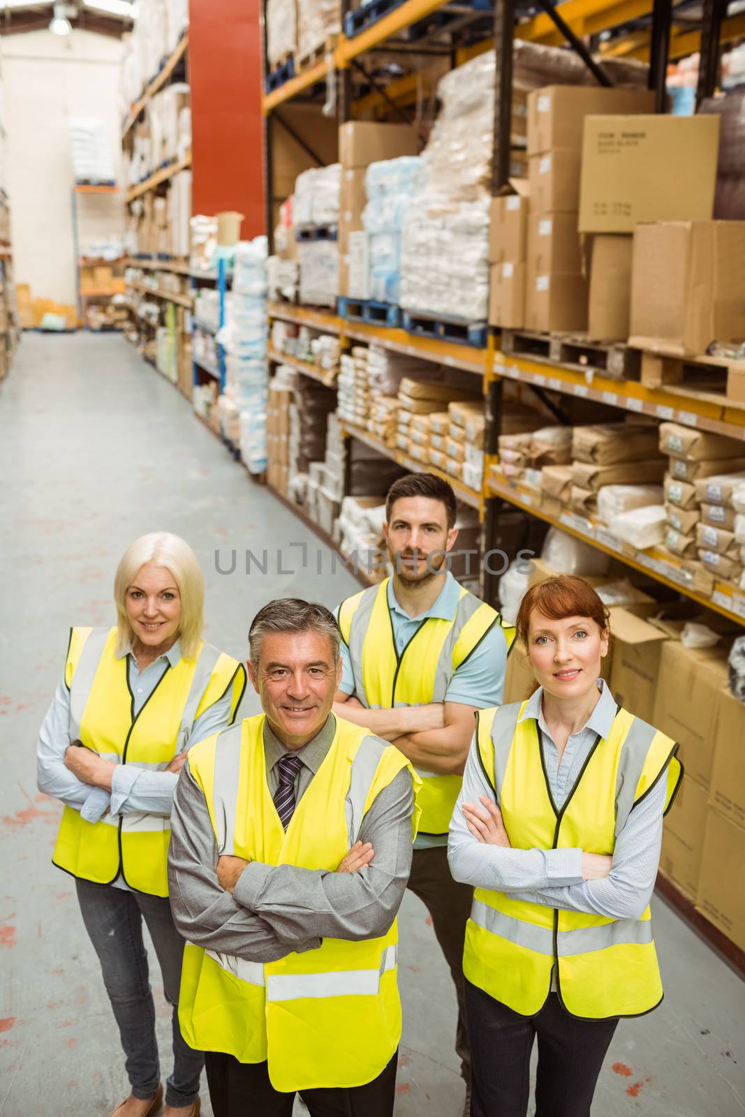 Smiling warehouse team with arms crossed by Wavebreakmedia