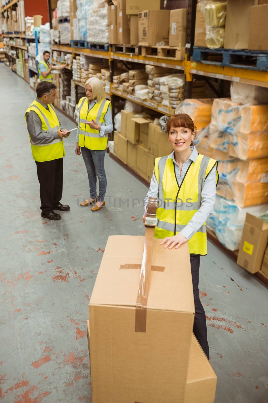 Warehouse worker sealing cardboard boxes for shipping by Wavebreakmedia