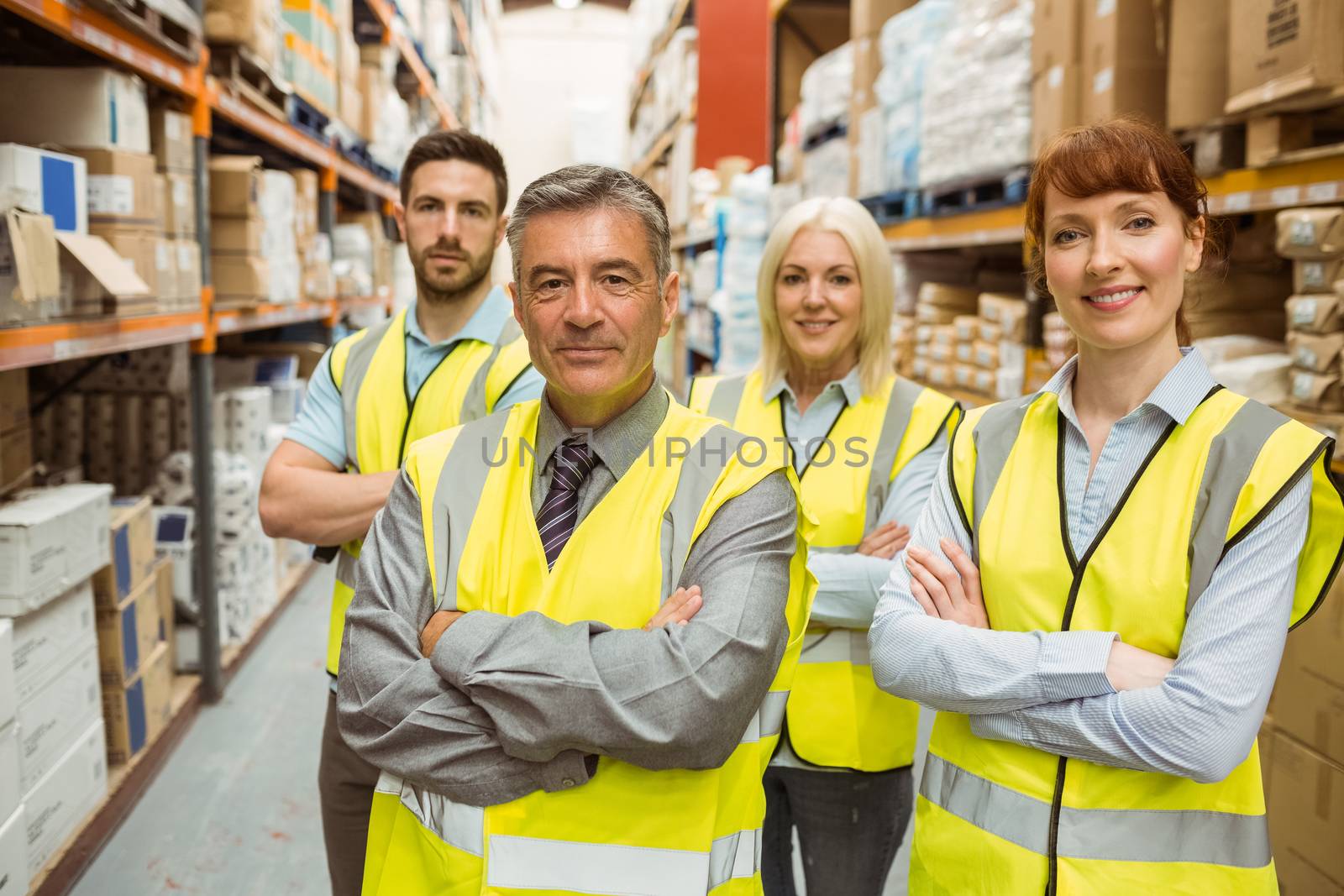 Smiling warehouse team with arms crossed by Wavebreakmedia
