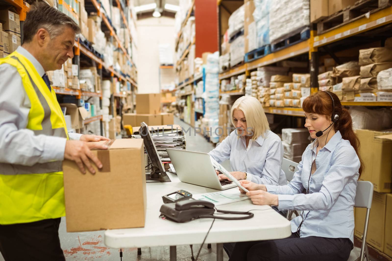 Warehouse team working together on shipment in a large warehouse