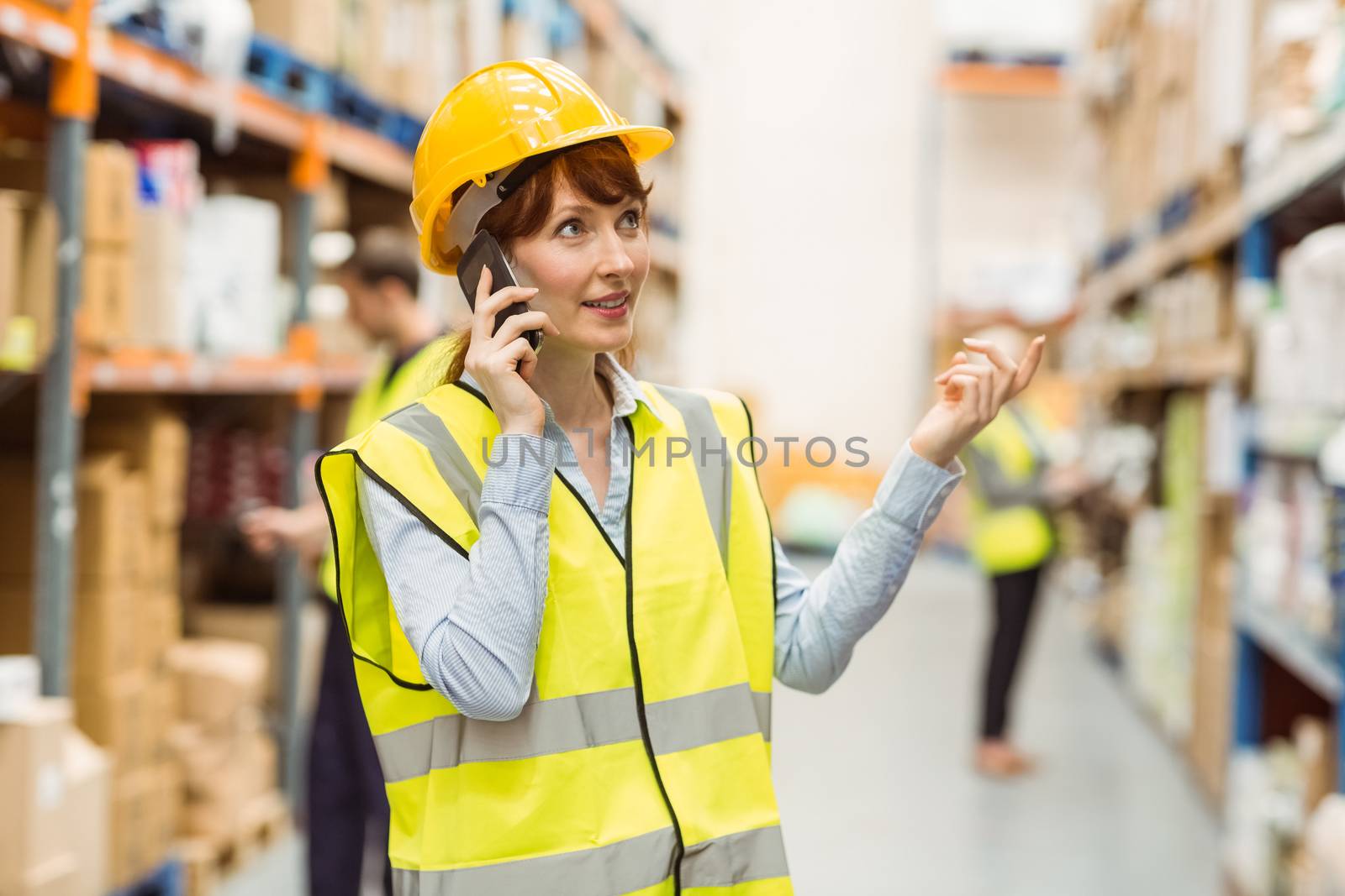 Warehouse manager talking on the phone looking around by Wavebreakmedia