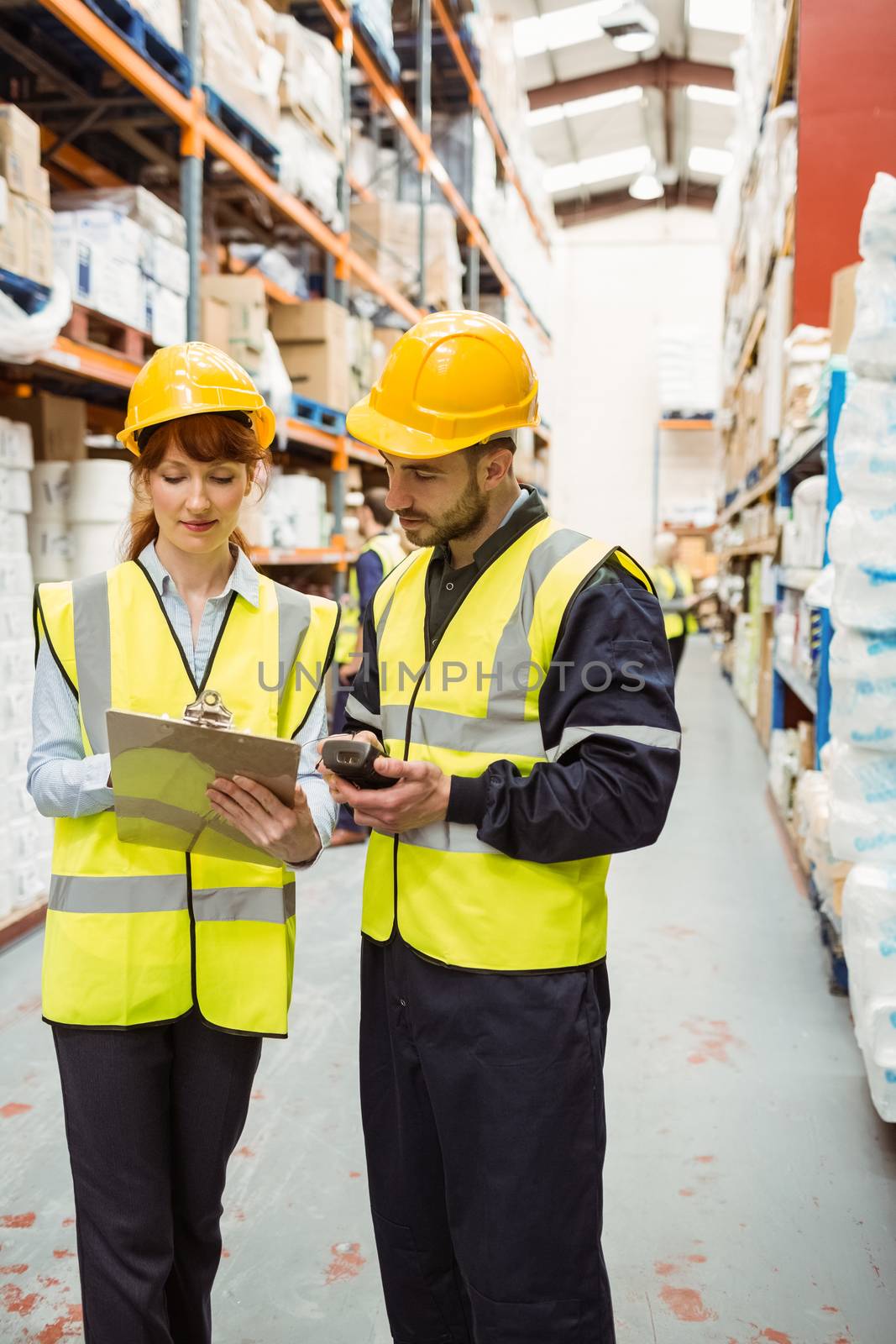Warehouse manager talking with worker by Wavebreakmedia