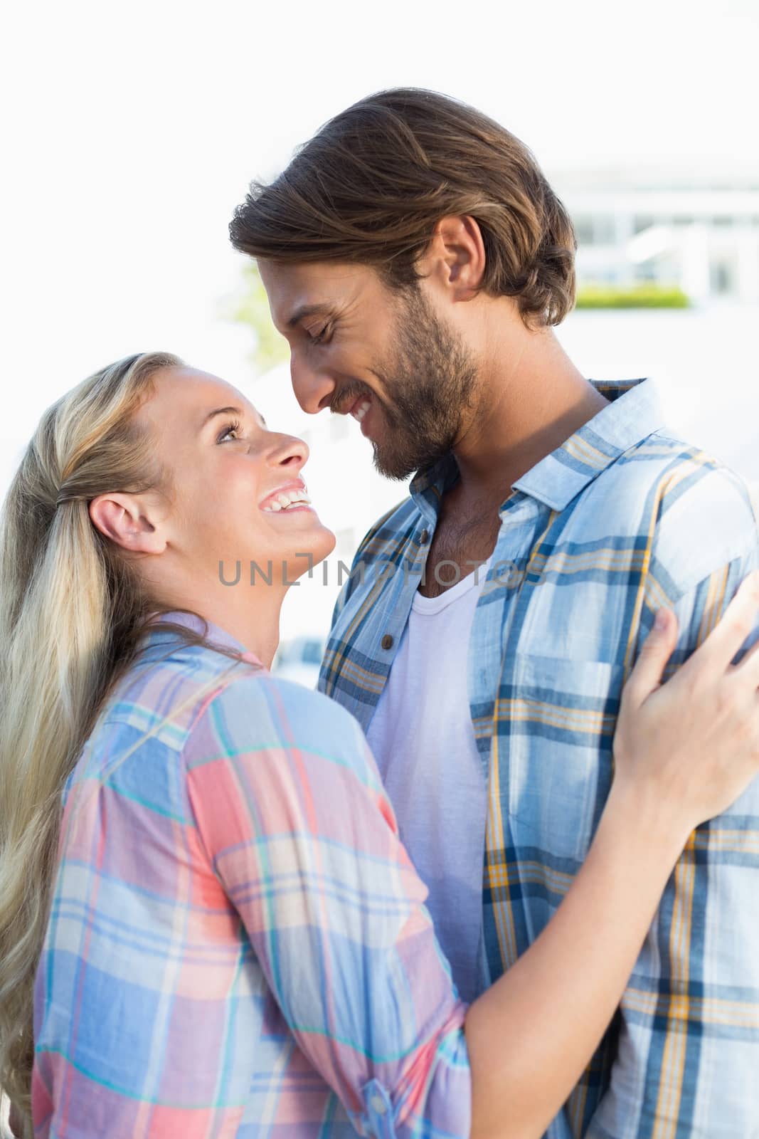 Attractive couple standing and hugging on a sunny day in the city