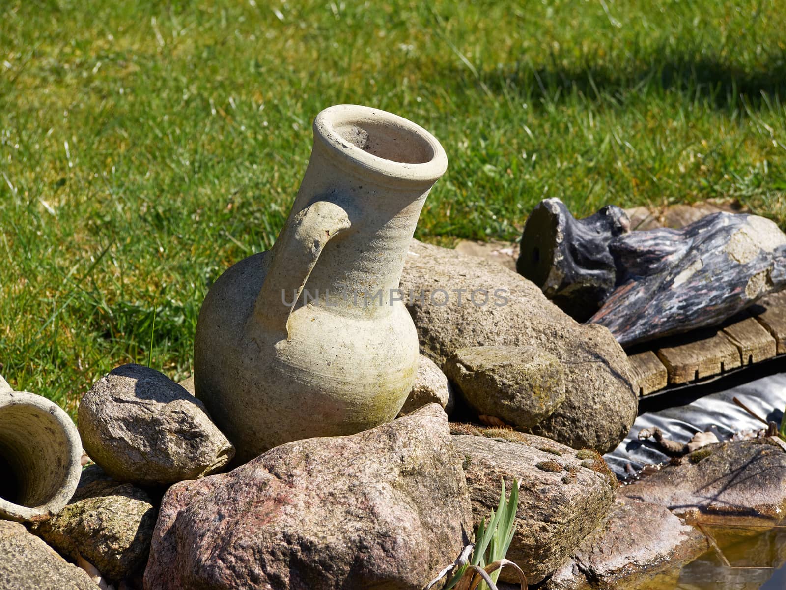 Handmade stone jar as a decoration item in a garden