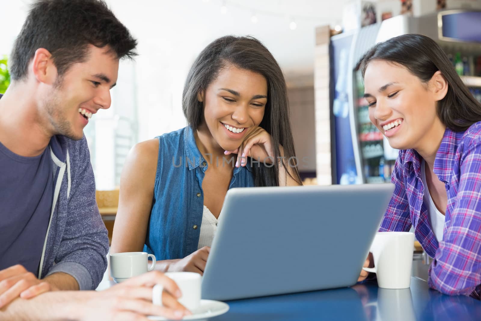 Young students doing assignment on laptop together by Wavebreakmedia