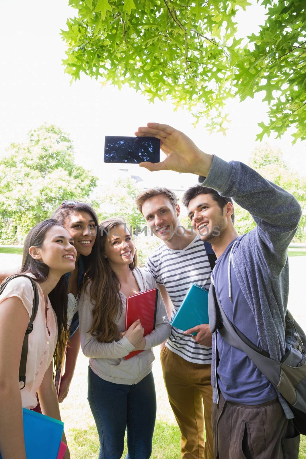 Happy students taking a selfie outside on campus at the university