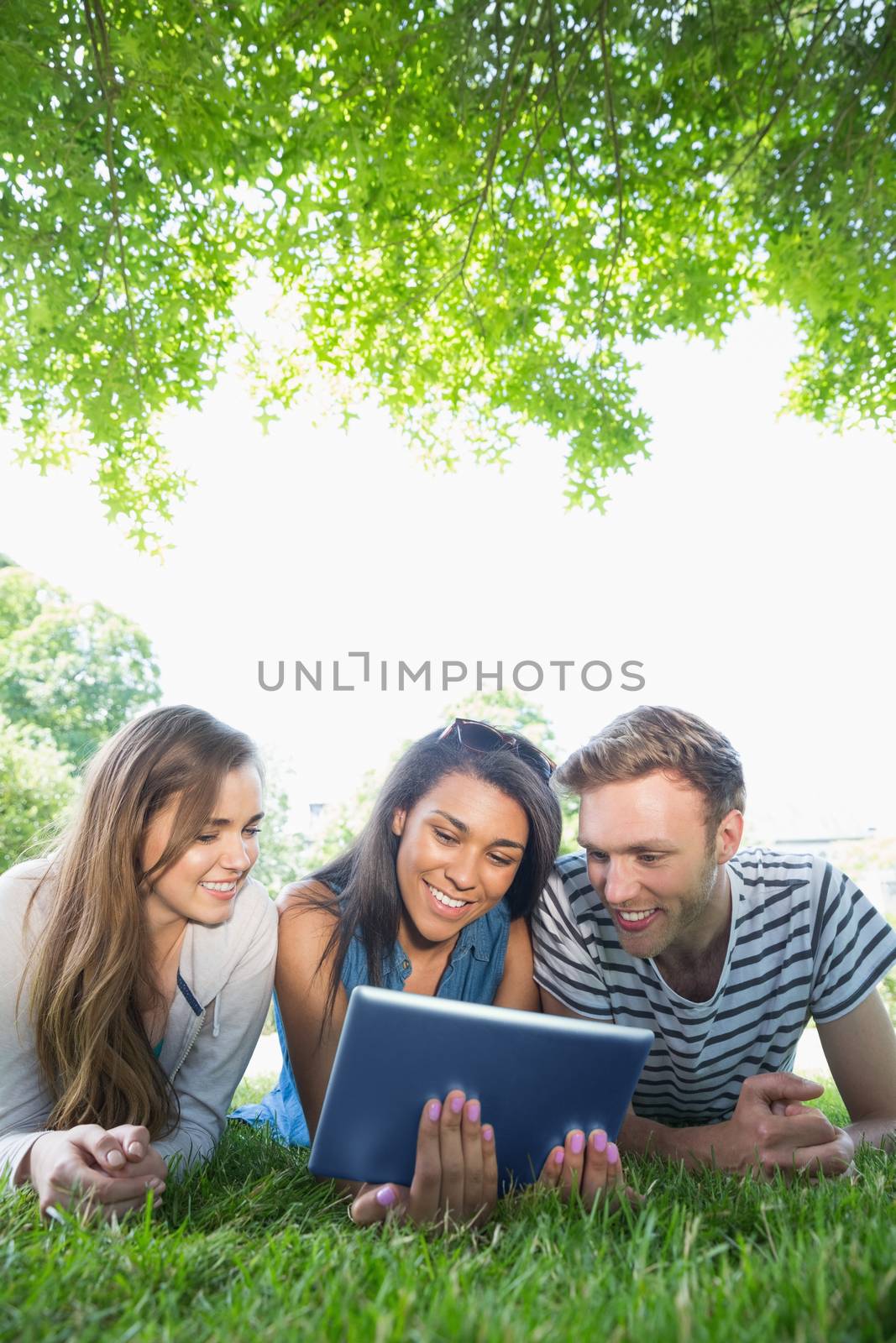 Happy students using tablet pc outside at the university