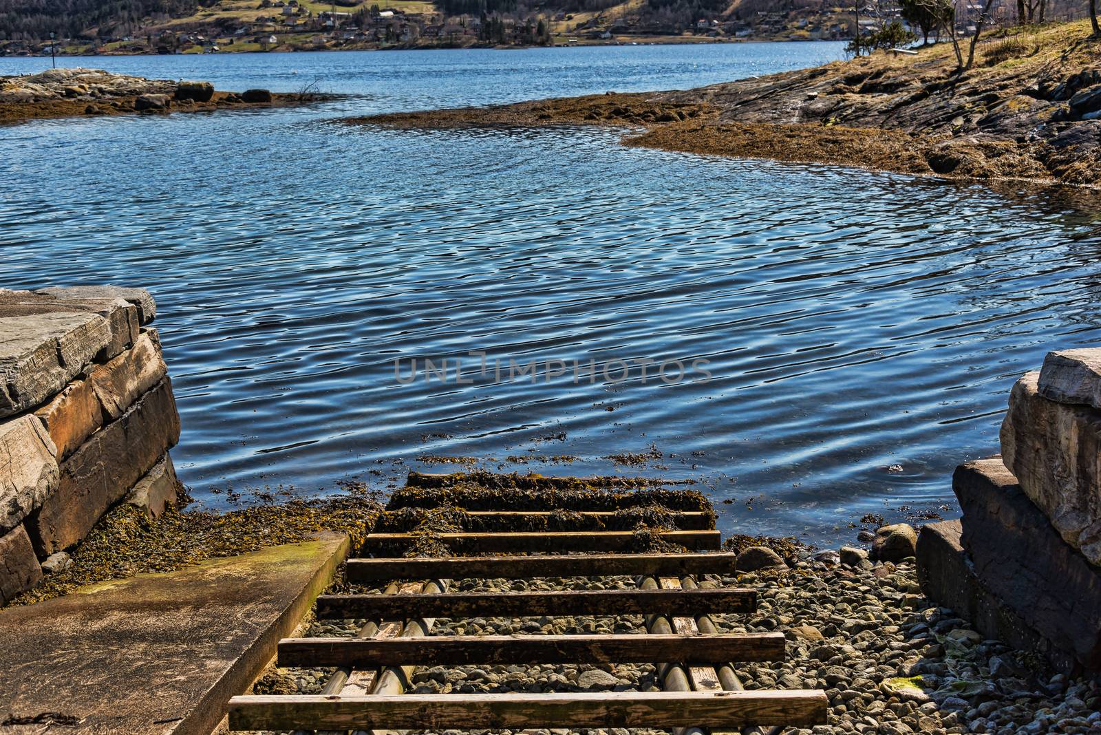 A boat landing with wooden sleepers by a Norwegian fjord