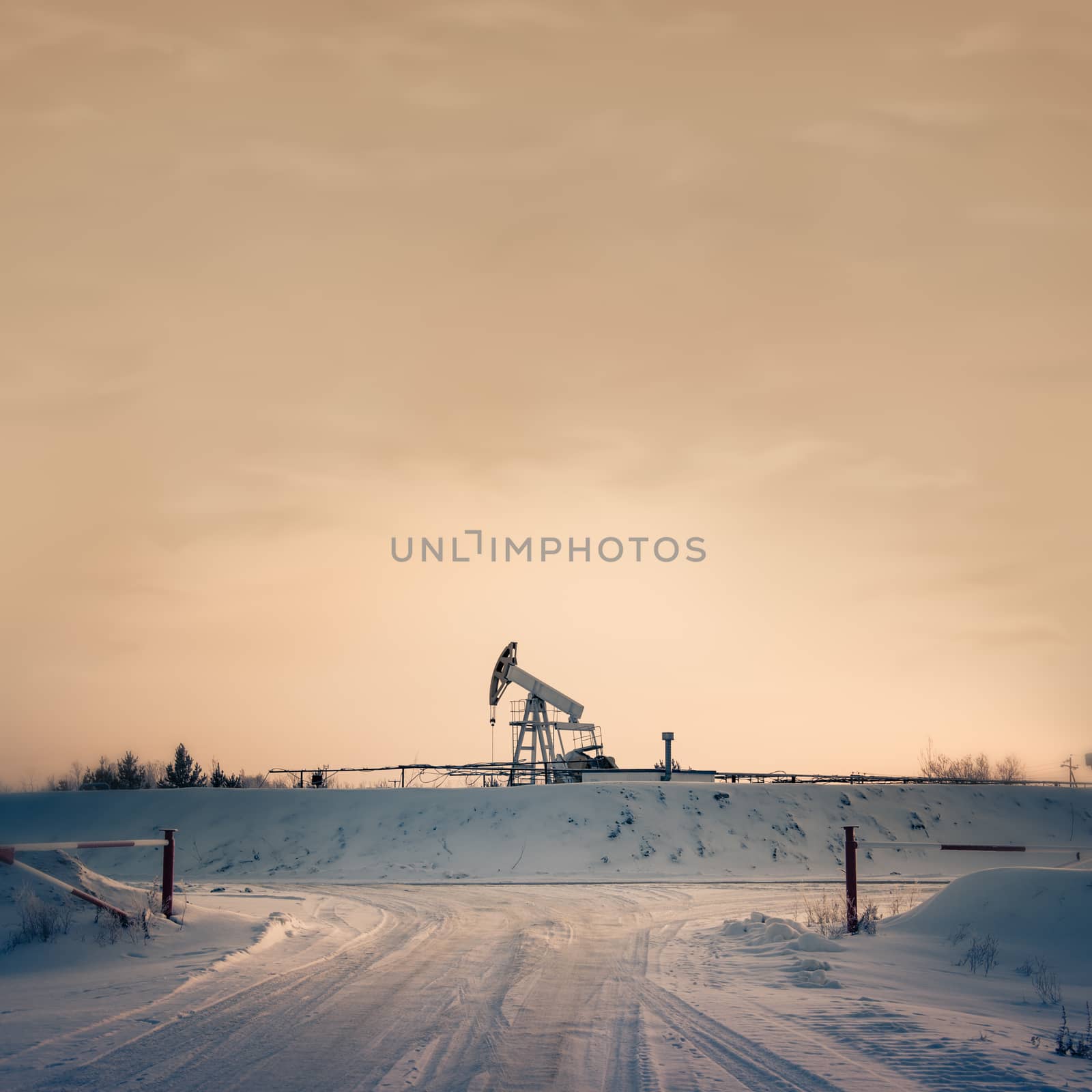 Pump jack on a sky background. Toned. Square format.